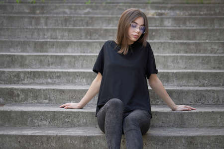 Woman or girl wearing black blank cotton t-shirt with space for your logo, mock up or design in casual urban styleの写真素材