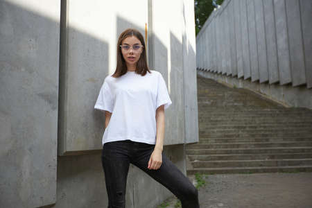 Girl or woman wearing white blank t-shirt with space for your logo, mock up or design in casual urban styleの写真素材