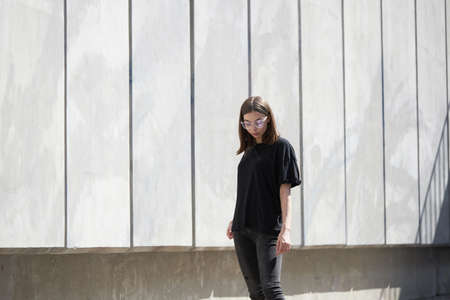 Woman or girl wearing black blank cotton t-shirt with space for your logo, mock up or design in casual urban styleの写真素材