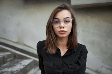 Fashion headshot of a sexy brunette woman with a make up wearing black dress in urban areaの写真素材