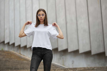 Girl or woman wearing white blank t-shirt with space for your logo, mock up or design in casual...