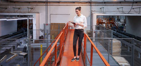 Business woman in Industrial Carpentry factory - production of wooden boards with modern machinesの写真素材