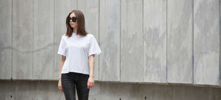 Girl or woman wearing white blank t-shirt with space for your logo, mock up or design in casual urban styleの写真素材