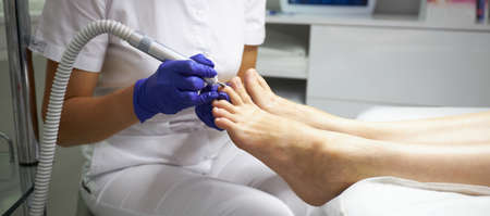 Peeling feet Pedicure SPA procedure in the beauty salon. Electric apparatus for pedicure. Woman getting her feet peeled in spa centerの写真素材