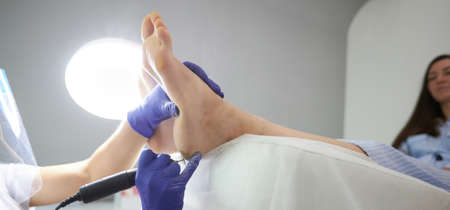 Peeling feet Pedicure SPA procedure in the beauty salon. Electric apparatus for pedicure. Woman getting her feet peeled in spa centerの写真素材