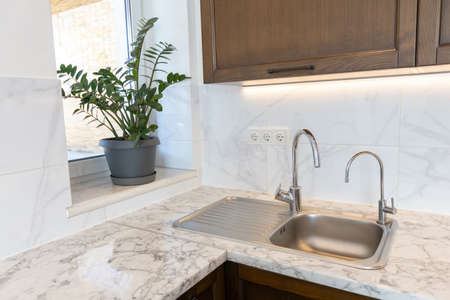 Modern metal water tap in the kitchenの写真素材
