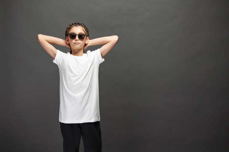 Kid girl wearing white t-shirt with space for your logo or design in studio over gray backgroundの写真素材