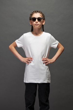 Kid girl wearing white t-shirt with space for your logo or design in studio over gray backgroundの写真素材