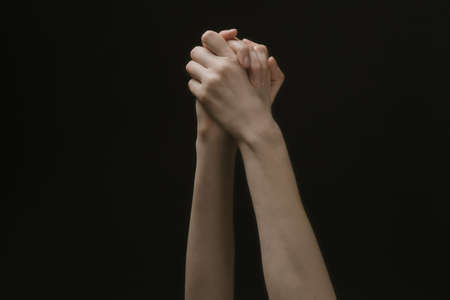Praying hands to God in the dark. Woman hands reaching out to God or for help in barokko styleの写真素材