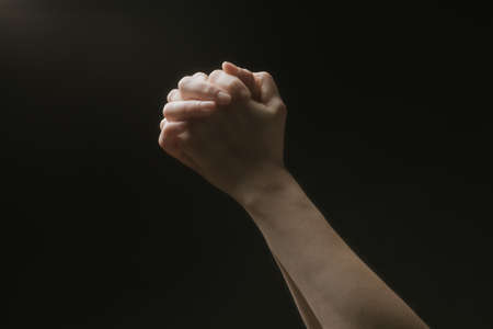 Praying hands to God in the dark. Woman hands reaching out to God or for help in barokko style