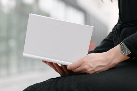 White book cover in woman's hands. Book cover for mock upの写真素材