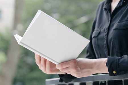 White book cover in woman's hands. Book cover for mock upの写真素材