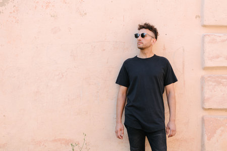 Hipster handsome male model wearing black blank t-shirt with space for your or design in casual urban styleの写真素材