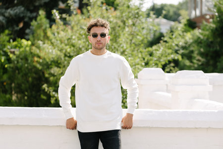 Man wearing white sweatshirt or hoodie for mock up, logo designs or design prints with with free space on the city streets.の写真素材