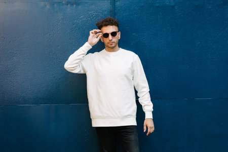 Man wearing white sweatshirt or hoodie for mock up, designs or design prints with with free space on the city streets.の写真素材