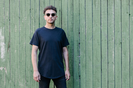 Hipster handsome male model wearing black blank t-shirt with space for your or design in casual urban styleの写真素材
