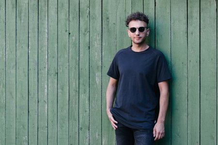 Hipster handsome male model wearing black blank t-shirt with space for your or design in casual urban styleの写真素材