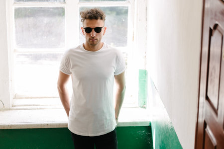 Hipster handsome male model wearing white blank t-shirt with space for your or design in casual urban styleの写真素材