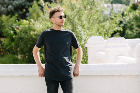 Hipster handsome male model wearing black blank t-shirt with space for your or design in casual urban styleの写真素材