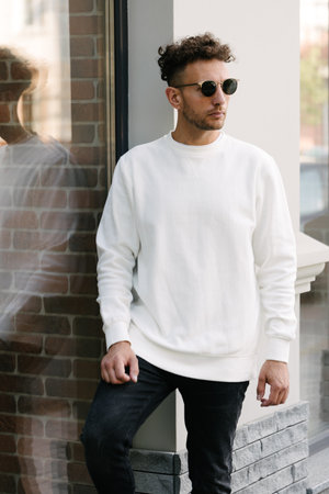 Man wearing white sweatshirt or hoodie for mock up, designs or design prints with with free space on the city streets.の写真素材