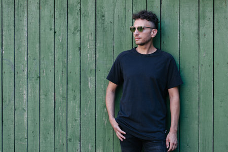 Hipster handsome male model wearing black blank t-shirt with space for your or design in casual urban styleの写真素材