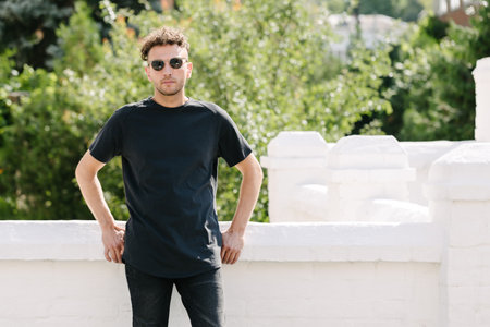 Hipster handsome male model wearing black blank t-shirt with space for your or design in casual urban styleの写真素材
