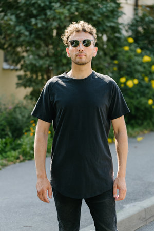 Hipster handsome male model wearing black blank t-shirt with space for your or design in casual urban styleの写真素材