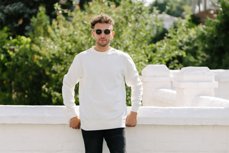 Man wearing white sweatshirt or hoodie for mock up, designs or design prints with with free space on the city streets.の写真素材