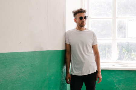 Hipster handsome male model wearing white blank t-shirt with space for your or design in casual urban styleの写真素材