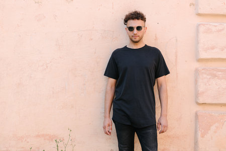 Hipster handsome male model wearing black blank t-shirt with space for your or design in casual urban styleの写真素材