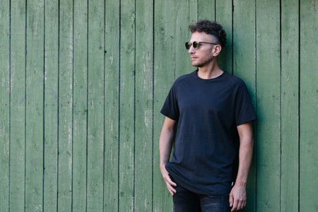 Hipster handsome male model wearing black blank t-shirt with space for your or design in casual urban styleの写真素材