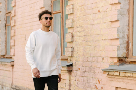 Man wearing white sweatshirt or hoodie for mock up, designs or design prints with with free space on the city streets.の写真素材