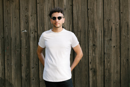 Hipster handsome male model wearing white blank t-shirt with space for your or design in casual...