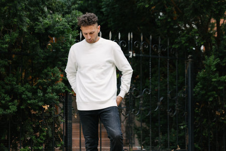Man wearing white sweatshirt or hoodie for mock up, designs or design prints with with free space on the city streets.の写真素材