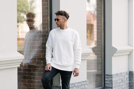 Man wearing white sweatshirt or hoodie for mock up, designs or design prints with with free space on the city streets.の写真素材