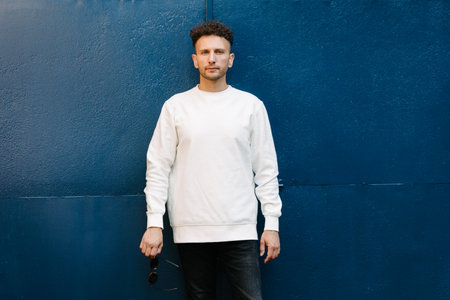 Man wearing white sweatshirt or hoodie for mock up, designs or design prints with with free space on the city streets.の写真素材