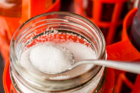 Spoon with granulated sugar in bottle. Close-up (selective focus).の写真素材