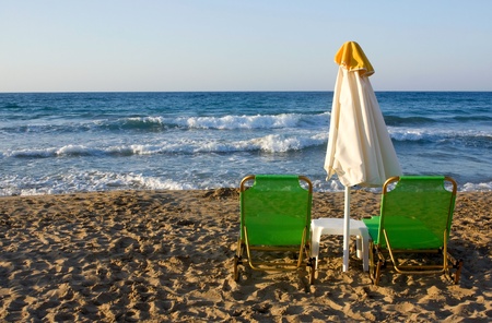 Sunbeds and sun umbrella on the beachの写真素材