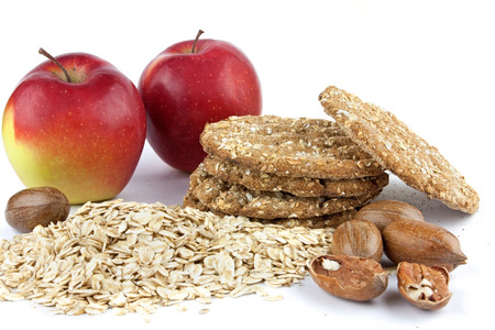 Apples with cereals, pecan nuts and biscuits on whiteの写真素材