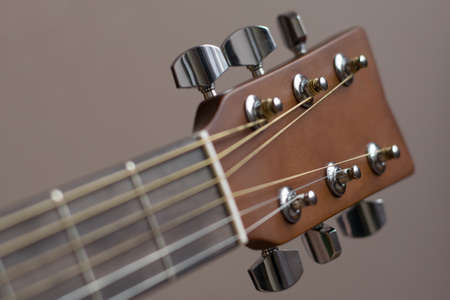 Headstock with tune machine head of acoustic six-string guitar close-up on black background