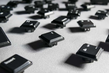 keys from the keyboard scattered on a gray fabric close-upの写真素材