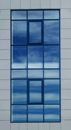 large opaque window with a reflection of a blue sky with clouds