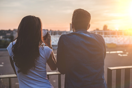 Beautiful romantic couple is having rest in the city on the sunset. Enjoying the company of each other.の写真素材
