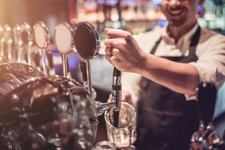 Cropped image of cheerful bartender on a bar counter is working and smiling.の写真素材