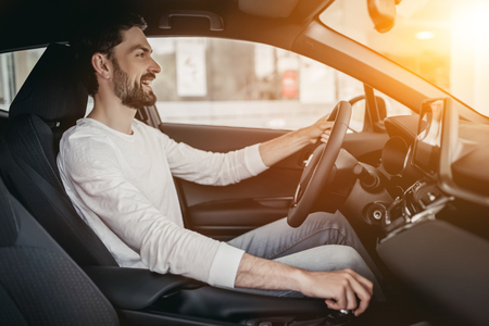 Young man is choosing a new vehicle in car dealership.の写真素材