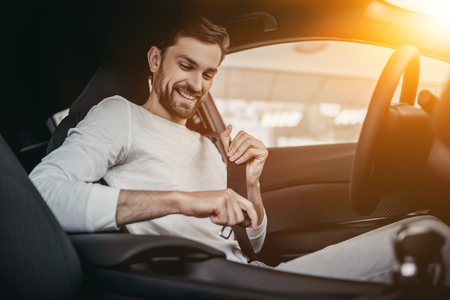 Young man is choosing a new vehicle in car dealership.の写真素材