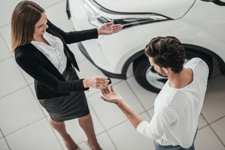 Professional salesperson during work with customer at car dealership.の写真素材