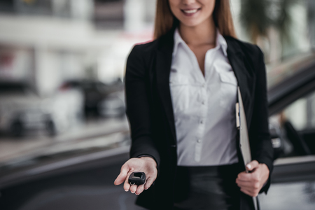 Cropped image of professional female salesperson at car dealership.の写真素材