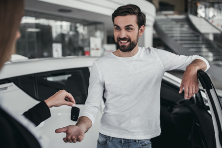 Professional salesperson during work with customer at car dealership.の写真素材