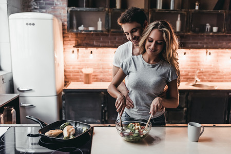 Attractive couple is cooking on kitchen.の写真素材